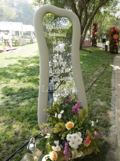 A custom-shaped mirror served as a welcome sign, with lyrics from a romantic song inscribed on it. This was a beautiful and personal way to greet guests as they arrived at the picnic.