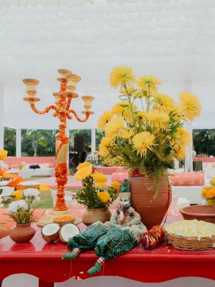 A close-up of a table centerpiece from our 'Haldi Holi' event. We even sprinkled some of the holi colors onto the flowers themselves, a fun little detail that tied everything together perfectly.
