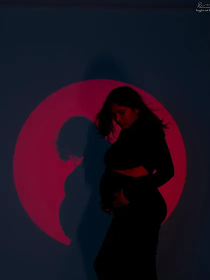 Adding a pop of color with a projected red circle. This creates a bold and dramatic silhouette, perfect for a memorable and artistic maternity photo.