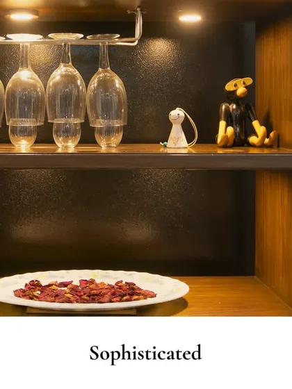 It’s the little corners that steal your heart. This cozy bar unit features glowing shelves for glassware and a few fun decor pieces, creating a small but charming retreat.