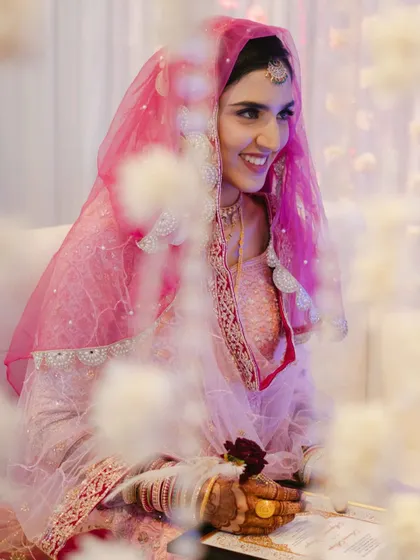 The bride's joyful smile during her "Qabool Hai" moment. Framed by flowers, this shot captures the happiness and beauty of her acceptance.
