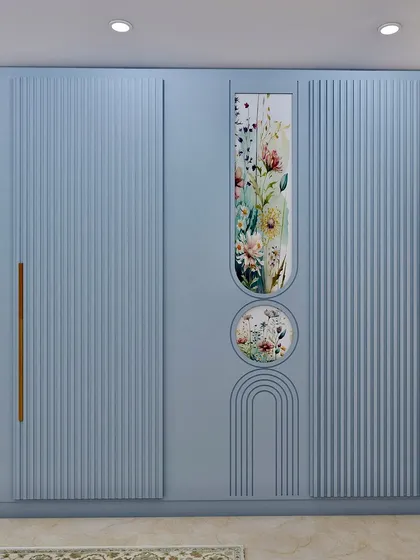 A close-up of the custom wardrobe, featuring fluted panels and a beautiful floral-patterned mirror insert.