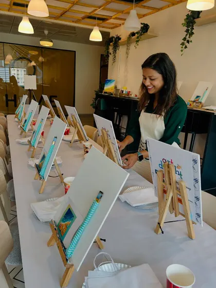 Here I am setting up the easels and canvases for a corporate event. I ensure everything is perfectly arranged so the team can just show up and start creating.