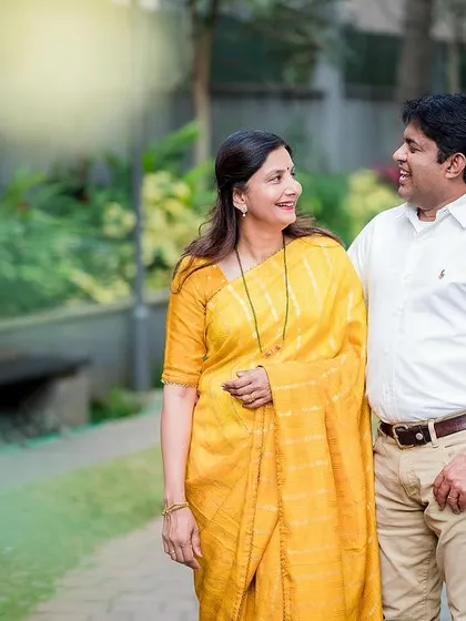 A candid photo of a couple enjoying a walk together in a park. Their relaxed smiles show their comfort and happiness with each other.
