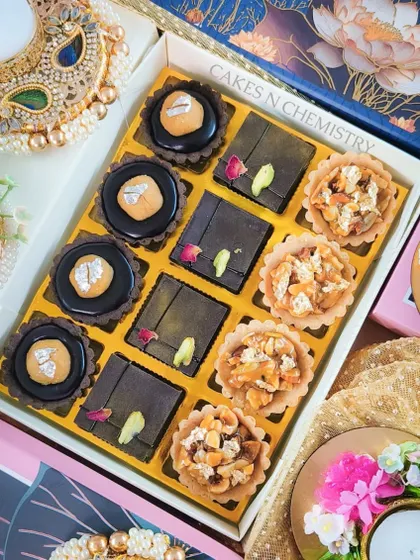 A box of assorted tarts from my Diwali 2023 menu. It includes a mix of chocolate tarts with an Indian twist and crunchy nut tarts, all beautifully arranged in a festive gift box.