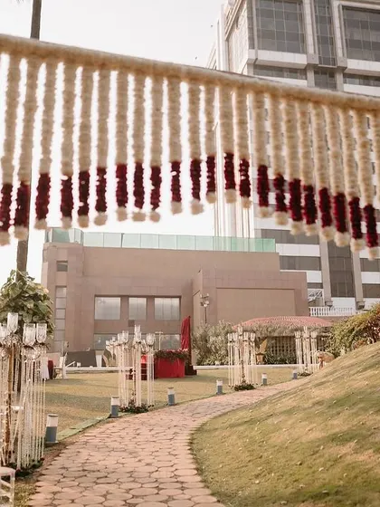 A floral archway made entirely of tuberose strings with a red rose border, creating a fragrant and beautiful entrance.