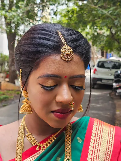 A close-up of Prakruthi's makeup, highlighting the golden shimmer on her eyes.