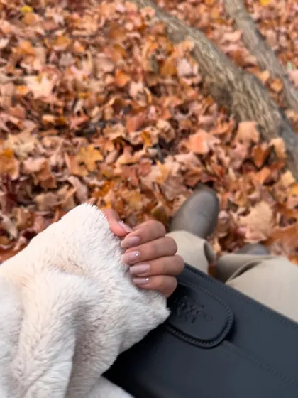 A close-up on my fall nails and cozy coat, with the autumn leaves of Blue Mountain in the background.