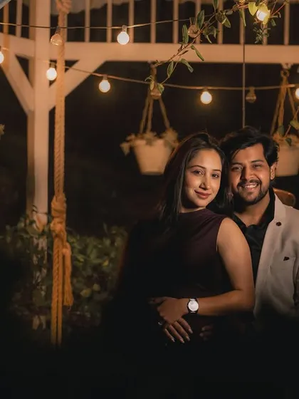 A cozy portrait of the couple under a gazebo strung with warm fairy lights. The ambient lighting creates a wonderfully intimate and romantic mood.