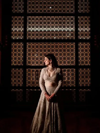 A dramatic bridal portrait using silhouette and backlighting from an ornate screen to create a moody and elegant image.