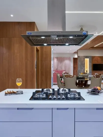 This kitchen island is a true workhorse, featuring a built-in hob, ample drawer storage, and a powerful chimney hood. It opens up to the dining area, making it perfect for entertaining while you cook.