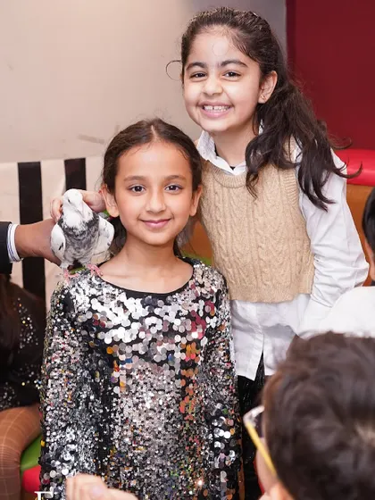 A magician performs a classic trick with a dove, amazing the young party guests.