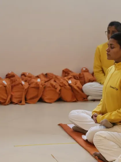 Students sit in meditation during the initiation ceremony for our teacher training course. In the background, bags are prepared for the new trainees, symbolizing the start of their immersive journey.