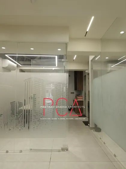Frosted glass partitions with a cityscape graphic at the StyleIn Homes office, providing privacy for workstations while maintaining a sense of openness and reinforcing an urban, corporate theme.