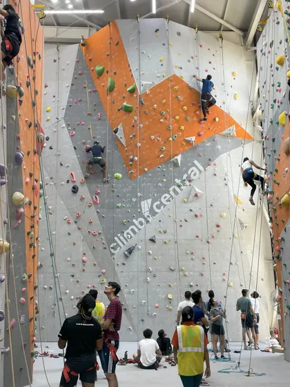 A wide view of our climbing arena, filled with people enjoying the sport. Every climb is a step towards progress, and we are here to support you on your journey.