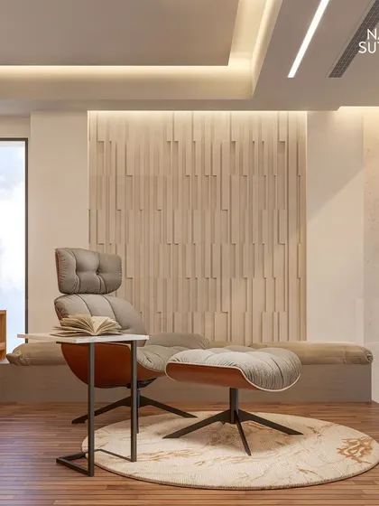 A quiet reading corner on the mezzanine, featuring a comfortable lounge chair and a textured wood-paneled wall. This space is designed for personal retreat and relaxation, showcasing our focus on creating mindful interiors.
