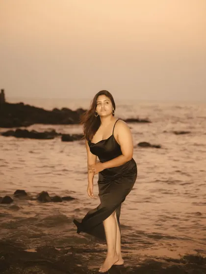 A dynamic shot from the beach series, with movement in the hair and dress. The golden hour light catches the motion, creating a feeling of freedom and spontaneity.