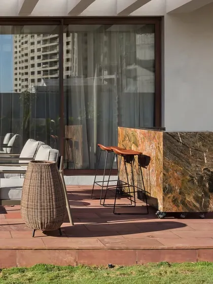This ground-floor terrace at the House of Terraces features a movable bar made from a single block of stone, blending functionality with a raw, natural aesthetic.