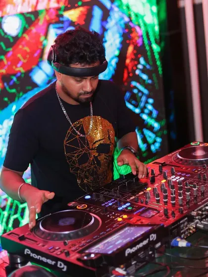 Focused on the mixer with a vibrant, abstract LED visual behind me. The combination of audio and visuals is key to my club sets.