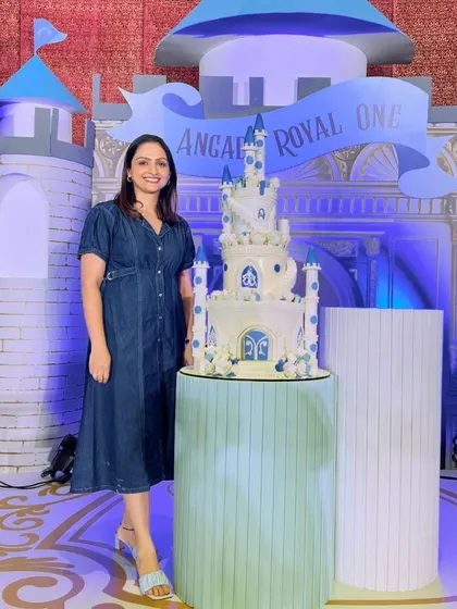 Standing proudly next to one of my grand castle cakes at a royal-themed first birthday party. Seeing the final setup is the best reward.