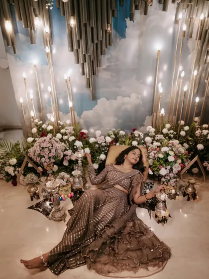 A dreamy Mehendi portrait. The bride is surrounded by flowers and candles, creating a magical and serene atmosphere.