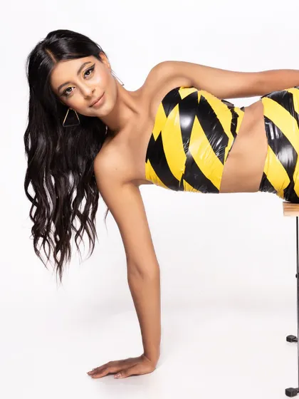A close-up of the model in the "caution tape" outfit, showing her playful expression.