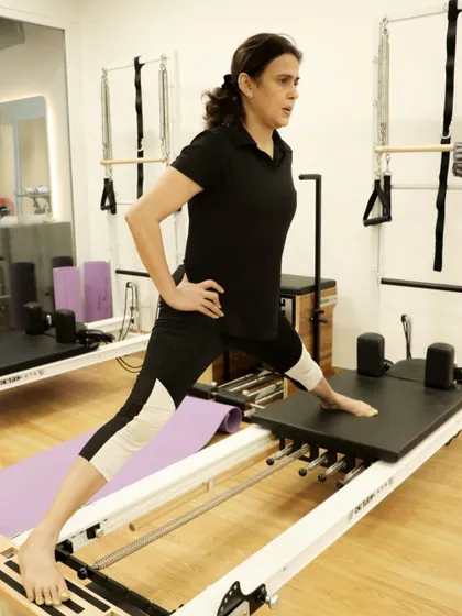 This client performs a side lunge on the reformer, a great exercise for targeting the inner thighs and improving hip mobility.