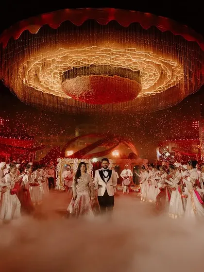 Another angle of the spectacular reception entry, showing the couple surrounded by a troupe of dancers in a perfectly choreographed welcome.
