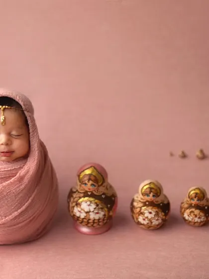 A unique and artistic concept featuring Russian nesting dolls. This shot plays with scale and color to create a truly memorable and creative portrait.