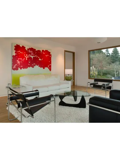 A living room that blends modern art with classic furniture design. The bold red painting provides a vibrant pop of color against the neutral background.