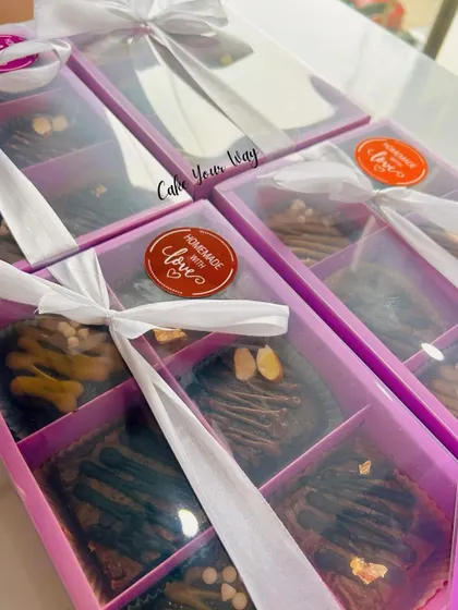 My brownie boxes are perfect for gifting. Here they are, all packed up with a "Homemade with Love" sticker and tied with a white ribbon, ready to be sent out as thoughtful and delicious presents.