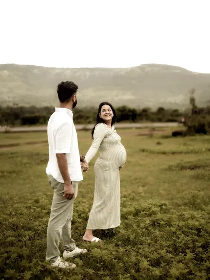 A beautiful, candid moment of the couple walking hand-in-hand through a field. Her backward glance and smile capture a fleeting, joyful interaction.