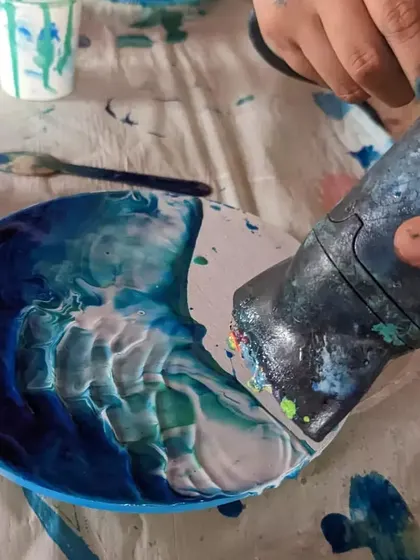 Using a heat gun to create the iconic lacing effect of ocean waves in resin art. It's a magical part of the process where the colors blend and cells form.