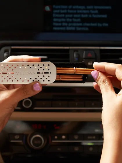 A close-up of our car fragrance set in action. The sleek, metallic vent clip is easy to use; just insert the natural rattan reeds for a sophisticated and lasting scent on your journey.