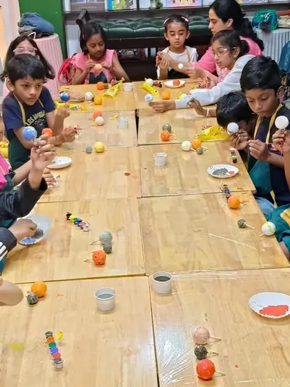 A wide view of our solar system painting session in full swing. It's a fantastic group activity where kids learn together while working on their individual projects.