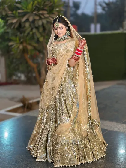 A full view of the gold sequin lehenga, showing its magnificent flare and how the light plays off the thousands of sequins. This is a true statement piece available for rent.