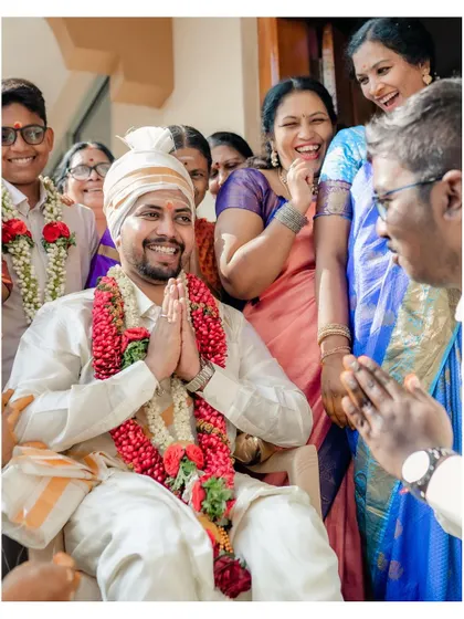 A joyful, candid moment of the groom surrounded by family and friends.