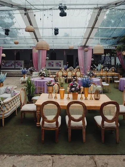An overview of the reception setup under the clear-top tent, showing a mix of round and long tables.