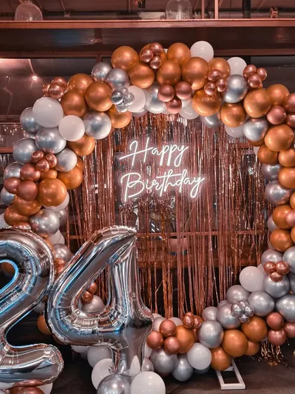 A 24th birthday with a rose gold, copper, and silver balloon ring against a shimmer backdrop.
