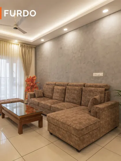 A minimalist living room featuring a comfortable L-shaped sofa against a grey textured accent wall. The design prioritizes simplicity and function, with clean lines and a focus on open space.