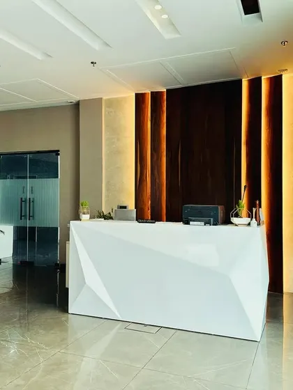 The reception area for M/s ALP in Ambala makes a powerful first impression. The design features a striking geometric desk, dramatic back-lighting on a wooden feature wall, and a polished marble floor, creating a modern and professional welcome for all visitors.
