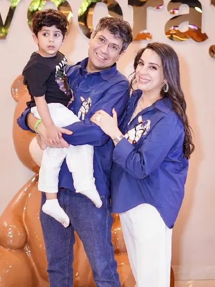 A family in matching outfits poses with our giant teddy bear mascot.