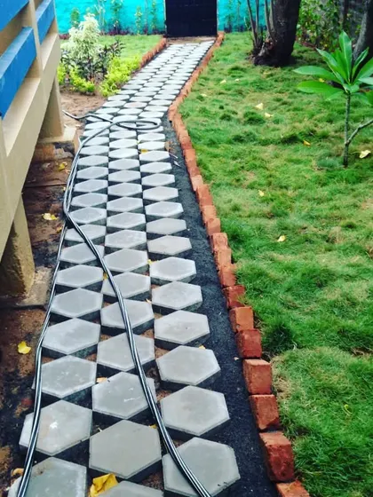 A pathway made of interlocking hexagonal pavers next to a new lawn. The brick border provides a clean separation between the two areas.