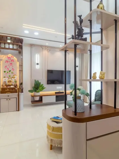 A view of a living room that includes a pooja unit and a decorative partition. This shows our ability to create multi-functional spaces that are both practical and aesthetically pleasing.