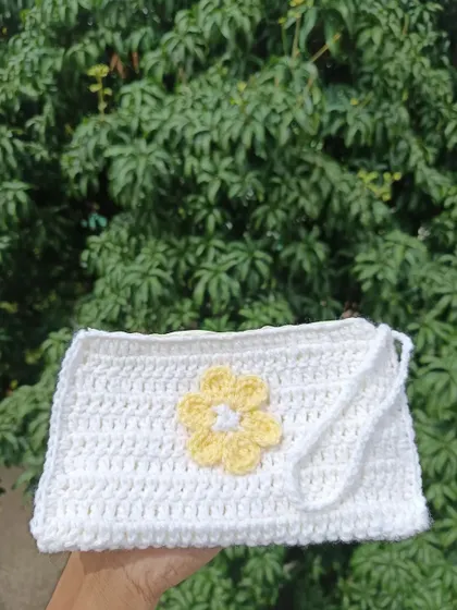 A simple white pouch with a yellow flower applique. This clean and fresh design is perfect for a spring or summer collection.