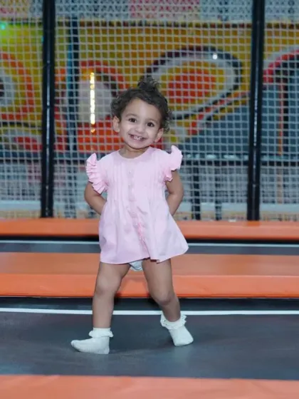 A little girl enjoys a moment of fun on the trampoline, showcasing the happy and carefree atmosphere we cultivate.
