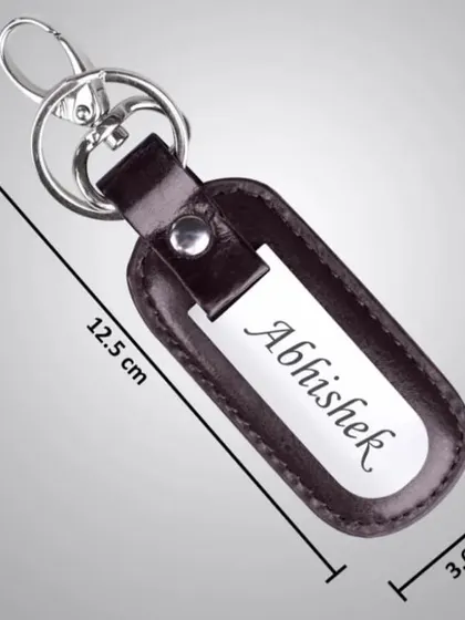 This personalized keychain features a leather holder with a metal plate for name engraving, complete with its dimensions for your reference.