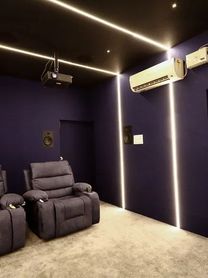 This shot shows the efficient use of space, with the speakers mounted on the walls and the projector on the ceiling, leaving the floor clear and uncluttered.