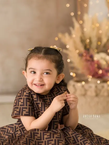 A delightful, candid portrait of a little girl with a charming, slightly mischievous smile. A perfect capture of her personality.