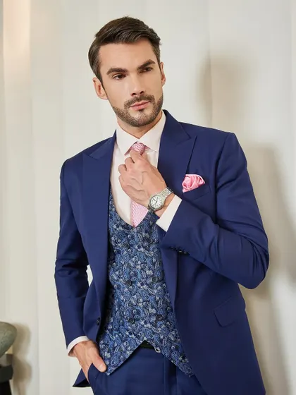 A close-up on the details that matter. The texture of the pink tie, the pattern of the jacquard waistcoat, and the perfect knot. Every element is carefully considered to create a harmonious and sophisticated final look.